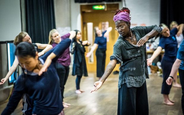 A group of people taking part in a world dance masterclass with participants of all ethnicities